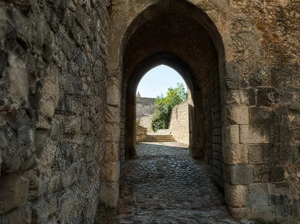 Ein steinernes Torbogen-Tor in einer Festungsmauer